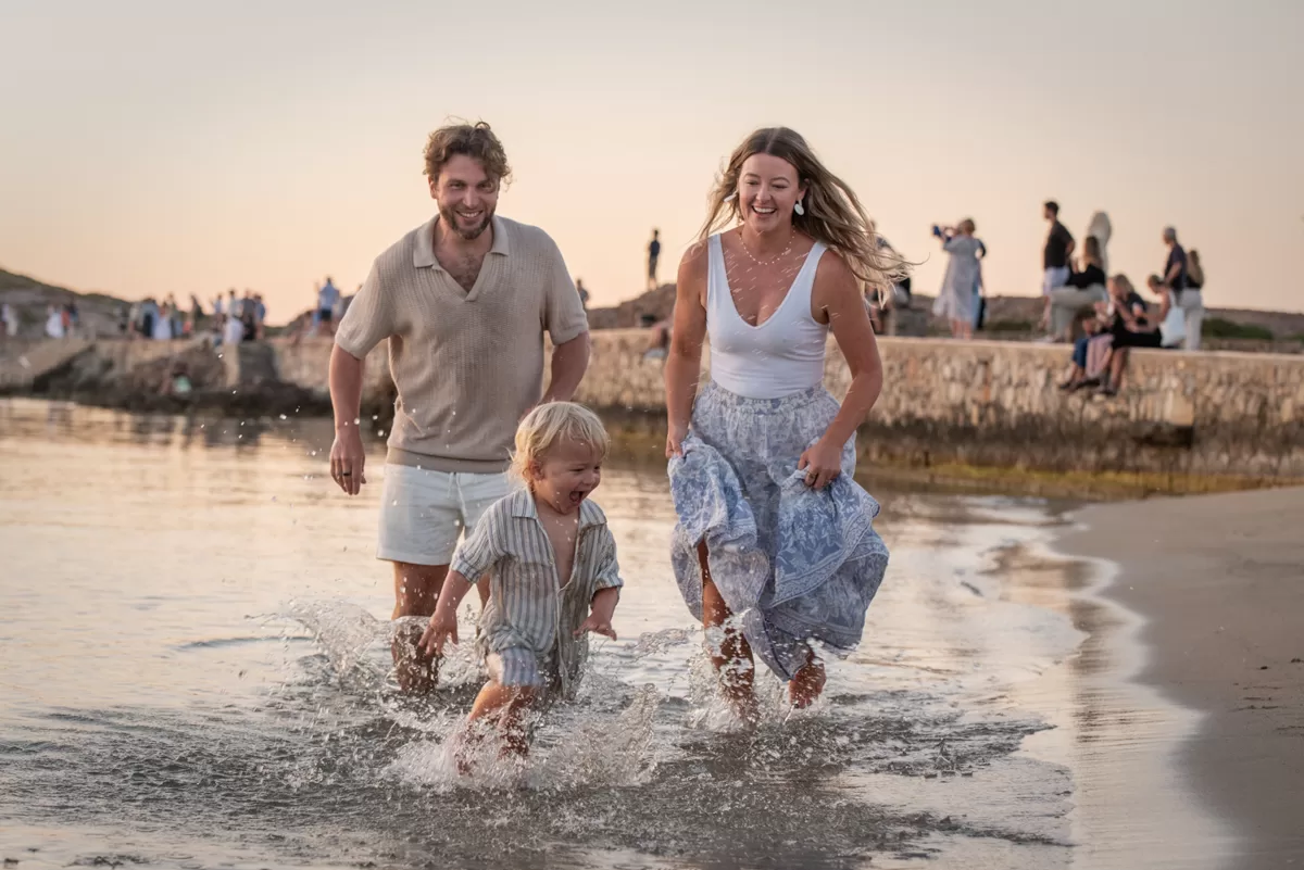 mam and dad chasing toddler splashing water around, by naxos photographer