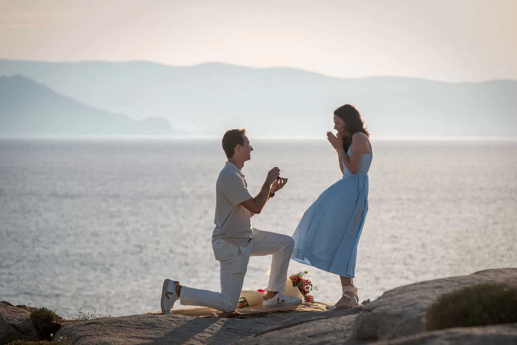A man getting down on his knee proposing at his girlfriend, in Agia Anna Naxos, captured by Naxos photographer