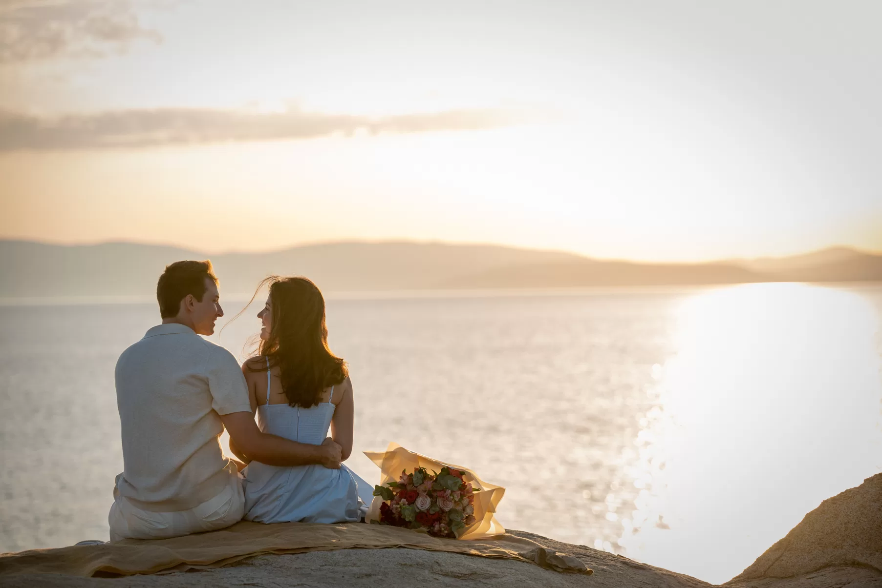Engaged couple looking over the sunset, captured by Naxos Photographer