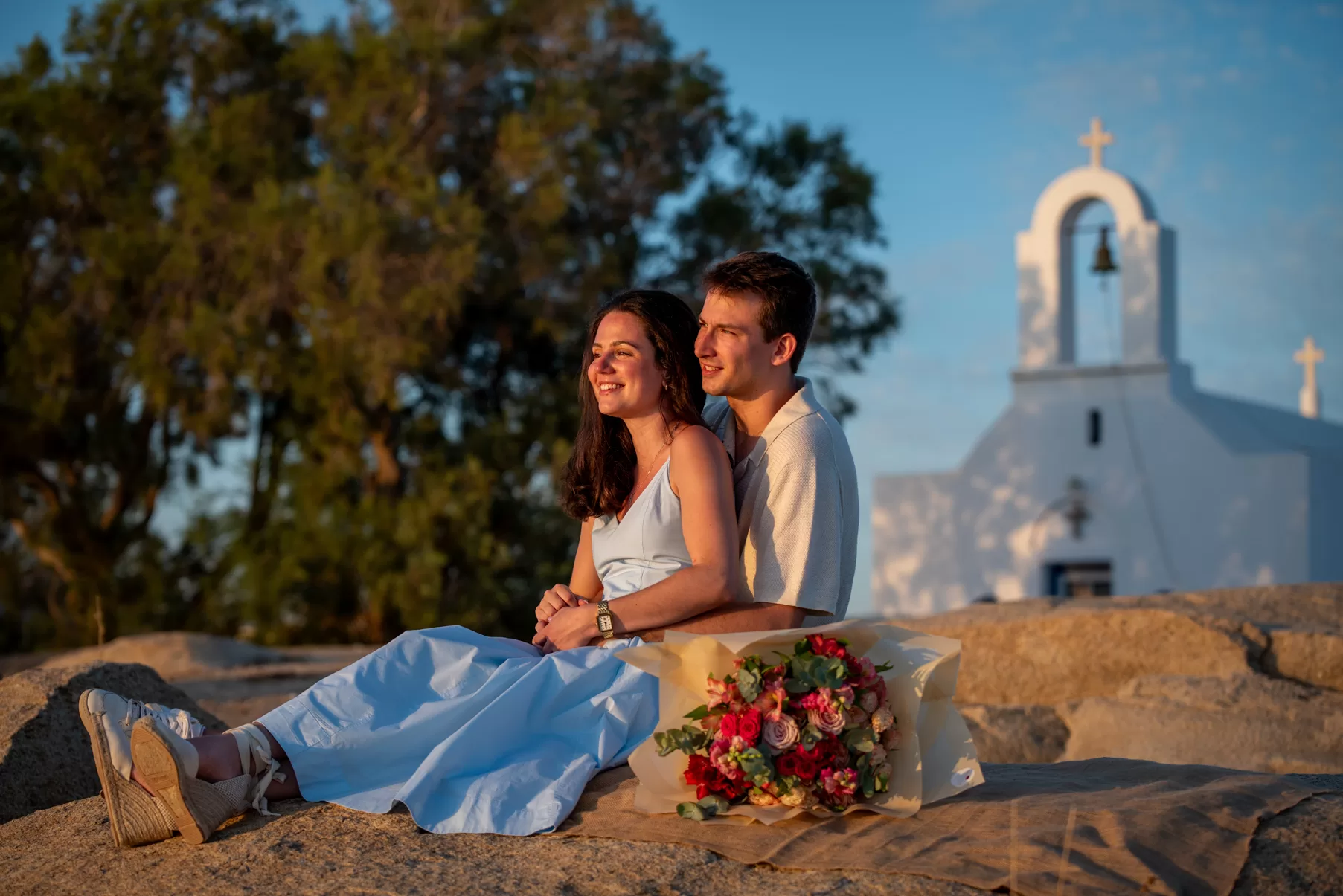 Engaged couple posing in front of picturesque church, captured by Naxos Photographer